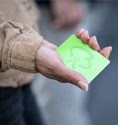 Hand som håller ett grönt busskort.