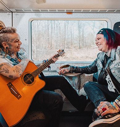 Två tjejer med tatuering sitter ombord på ett Öresundståg.