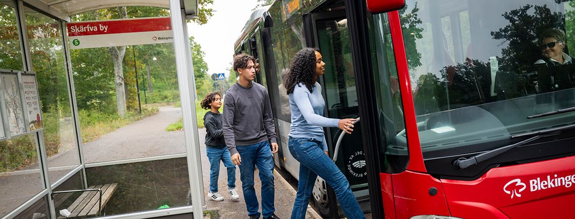 Tre ungdomar går ombord en buss.