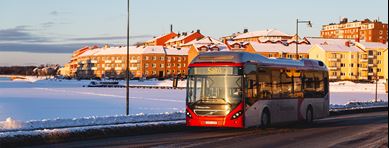 Buss som kör på väg i soligt vinterväder