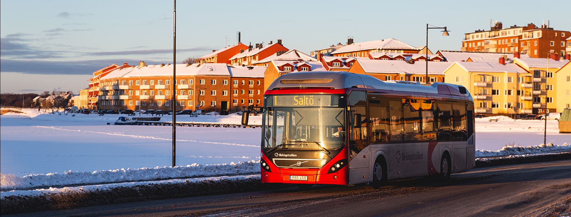 Buss som kör på väg i soligt vinterväder