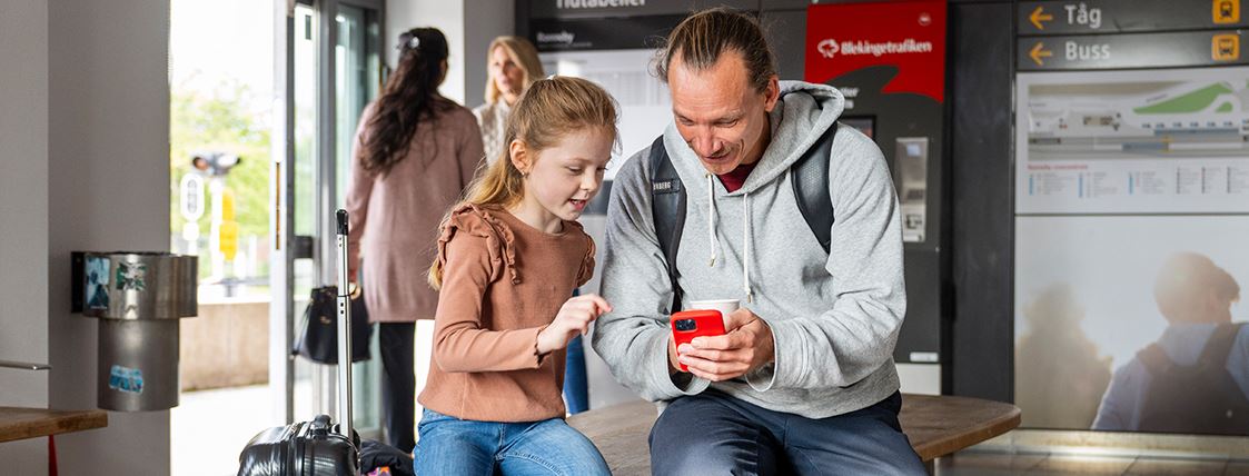 Ett barn tittar på sin pappas smartphone.